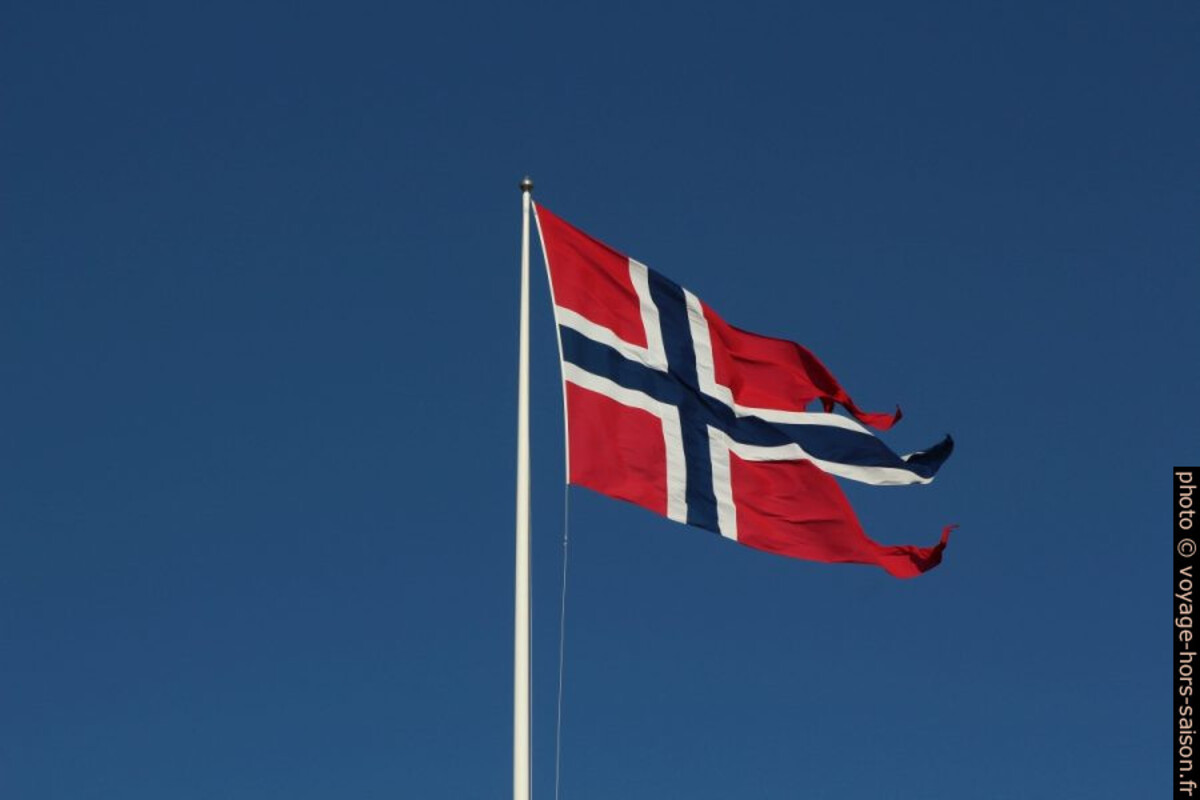 Drapeau norvégien d'État contre le ciel bleu d'hiver. Photo © André M. Winter