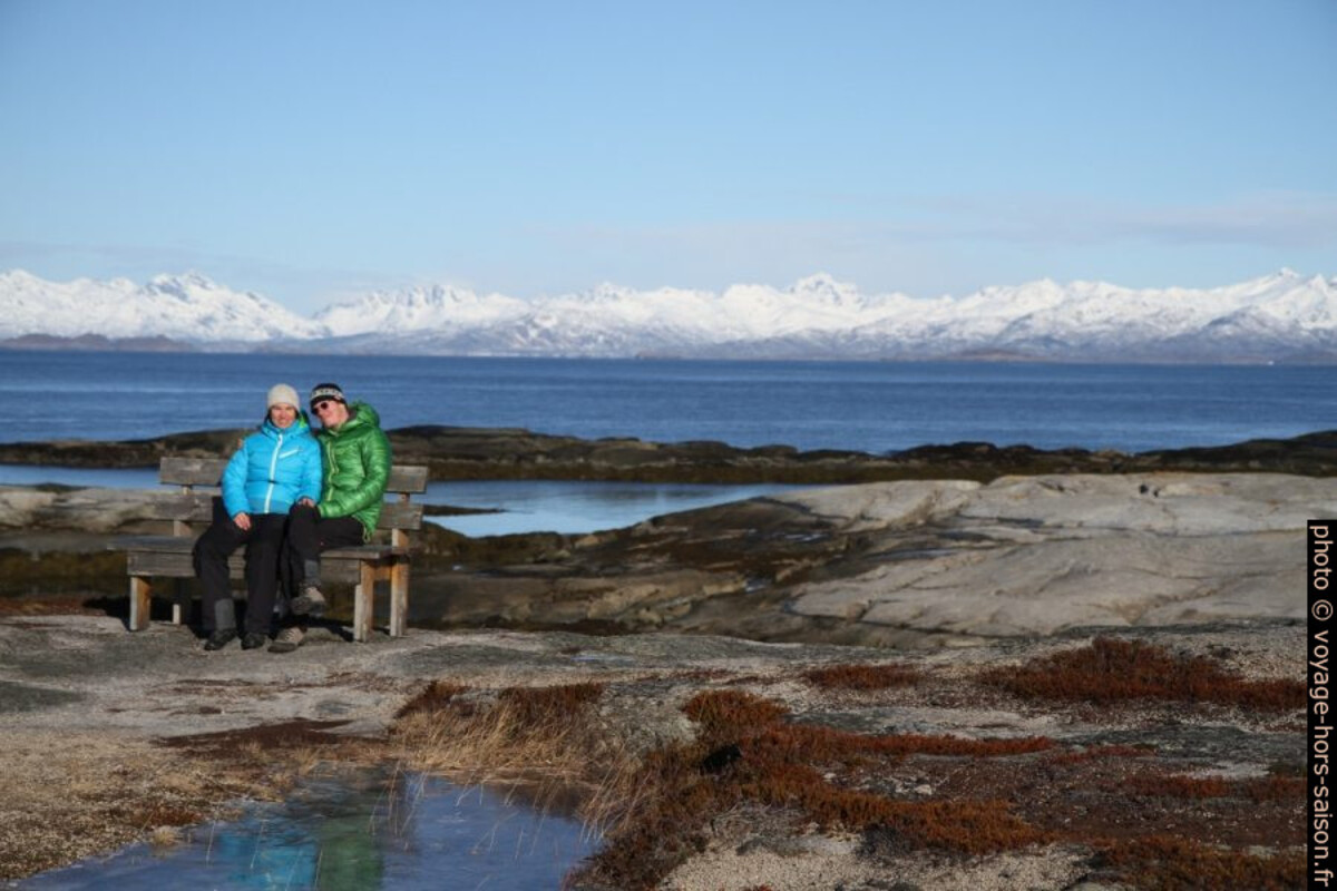 Alex et André assis sur le banc de Tranøy avec les Îles Lofoten au fond