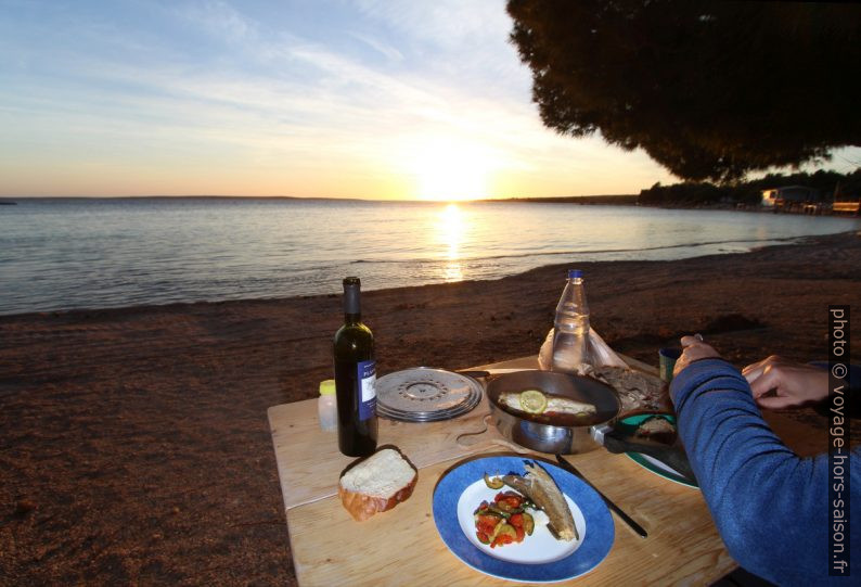 On mange avec le coucher du soleil sur la plage. Photo © André M. Winter
