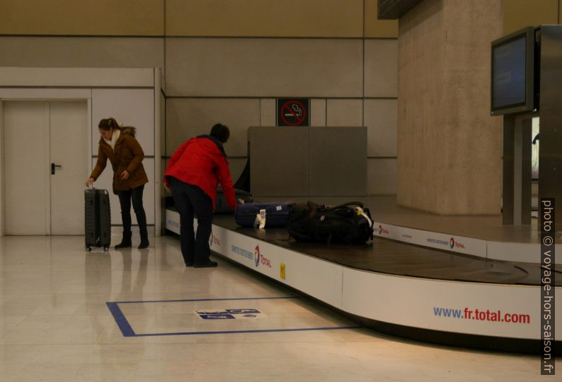 Alex retire une de nos valises à Roissy CGD. Photo © André M. Winter