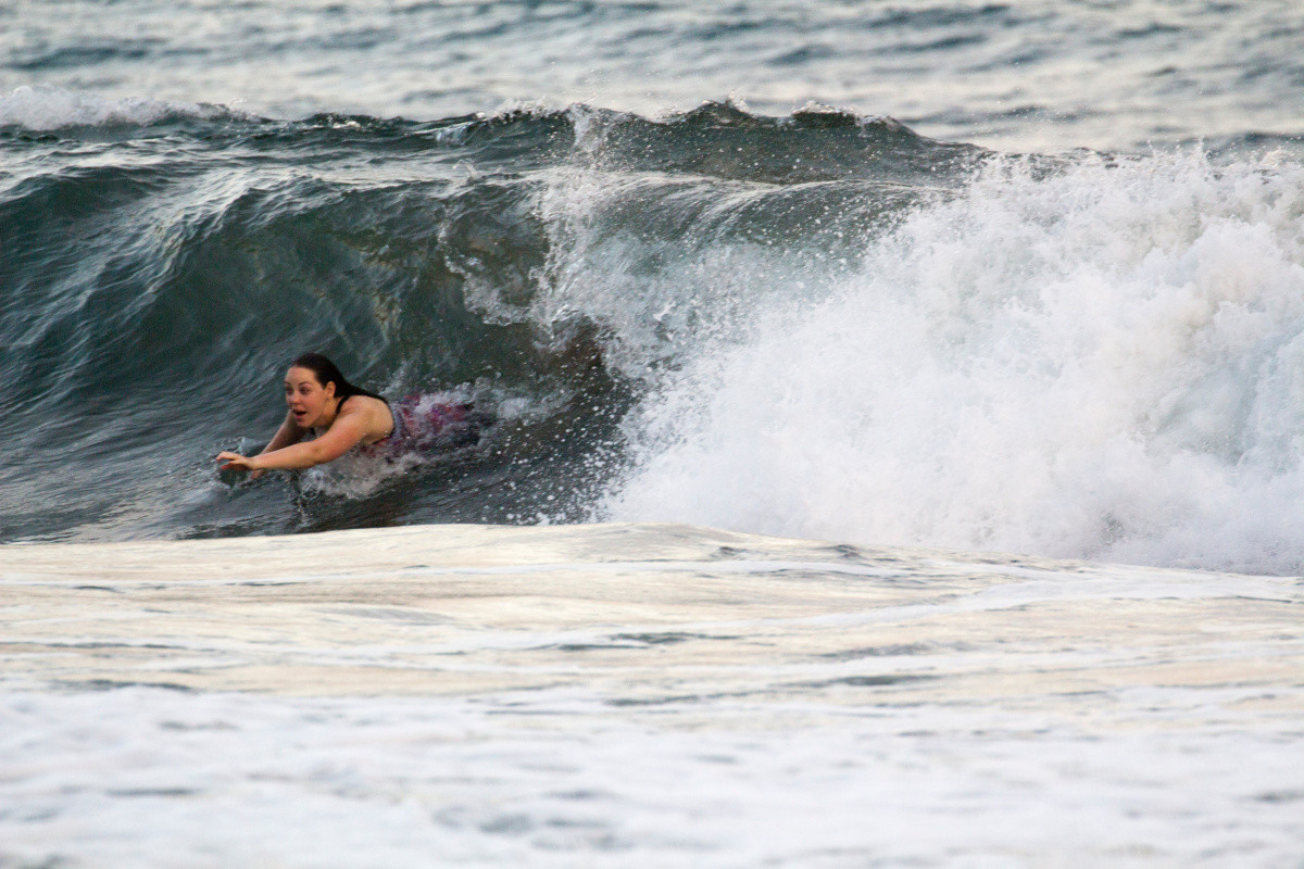 Une femme nage avec une déferlante. Photo © André M. Winter