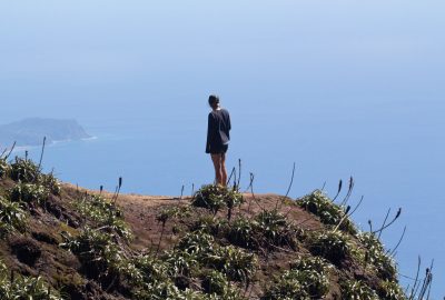 Une femme regarde les Saintes du plateau sommital de la Soufrière. Photo © André M. Winter