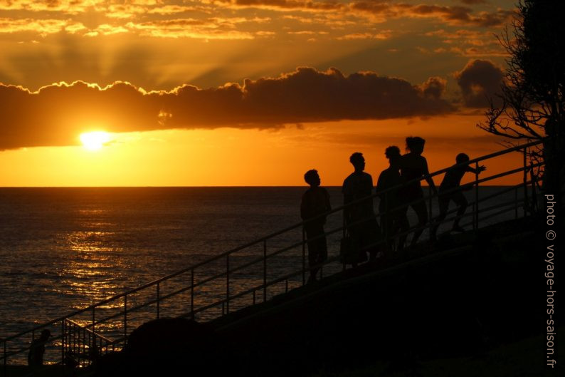 Des jeunes sur l'escalier menant au Phare de Vieux-Fort lors du coucher du soleil. Photo © André M. Winter