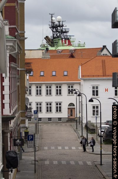 Le mât radar d'un navire de haute mer dépasse des maisons. Photo © André M. Winter