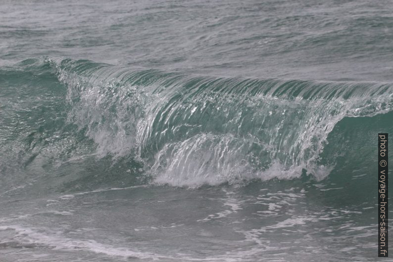 Une vague déferle sur la plage. Photo © André M. Winter