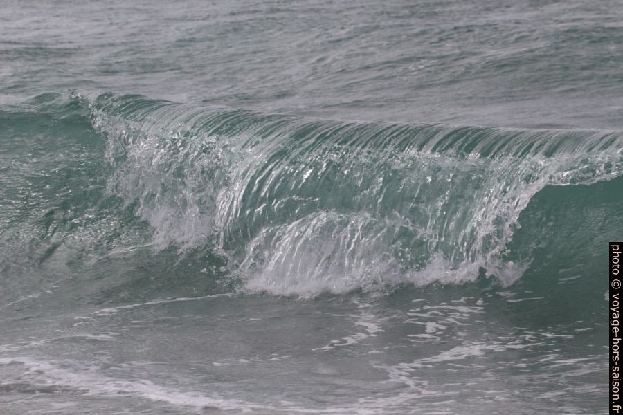Une vague déferle sur la plage. Photo © André M. Winter