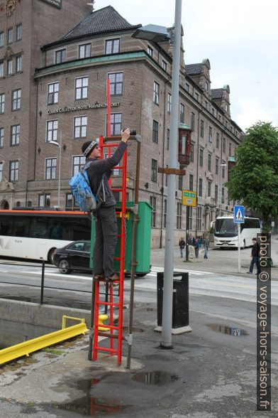 André monte sur une échelle pour photographier Bryggen. Photo © Alex Medwedeff