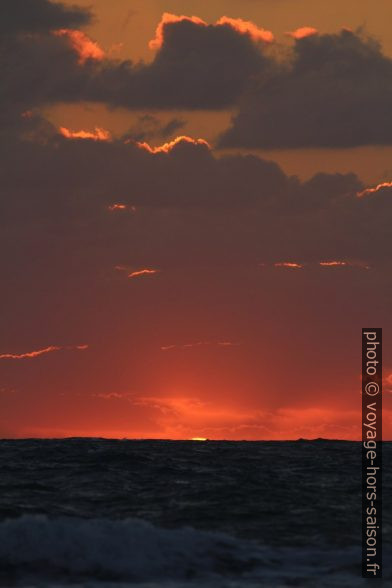 Dernier morceau du disque du soleil au-dessus de la mer. Photo © André M. Winter