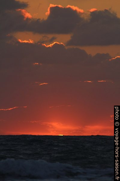 Dernier morceau du disque du soleil au-dessus de la mer. Photo © André M. Winter