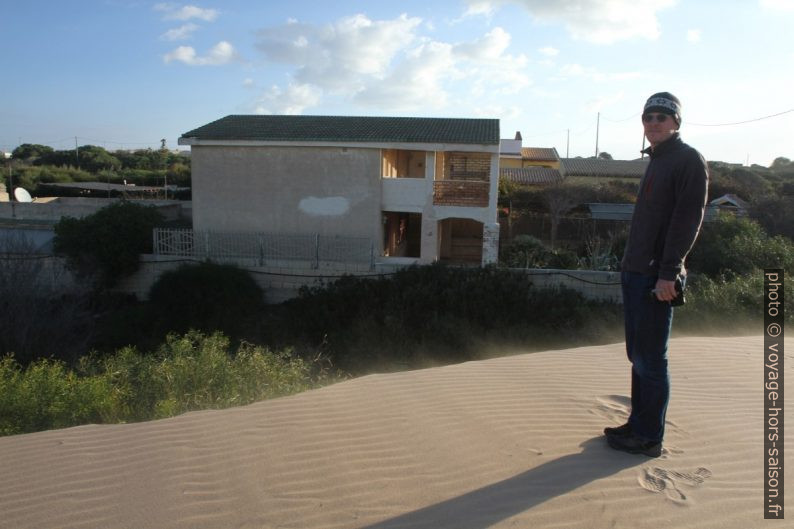 André sur une dune qui menace les maisons. Photo © Alex Medwedeff