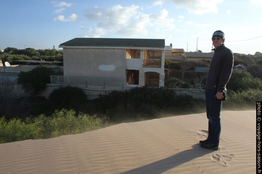 André sur une dune qui menace les maisons. Photo © Alex Medwedeff