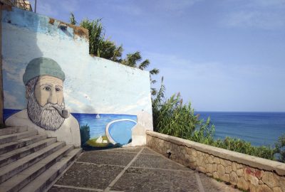 Escalier avec un mur peint d'une tête de marin à Rodi Garganico. Photo © André M. Winter