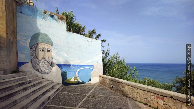 Escalier avec un mur peint d'une tête de marin à Rodi Garganico. Photo © André M. Winter