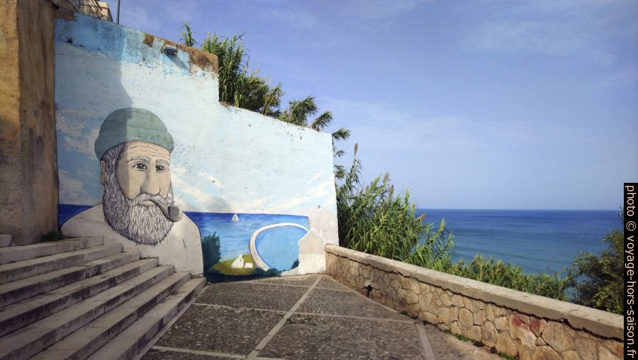Escalier avec un mur peint d'une tête de marin à Rodi Garganico. Photo © André M. Winter