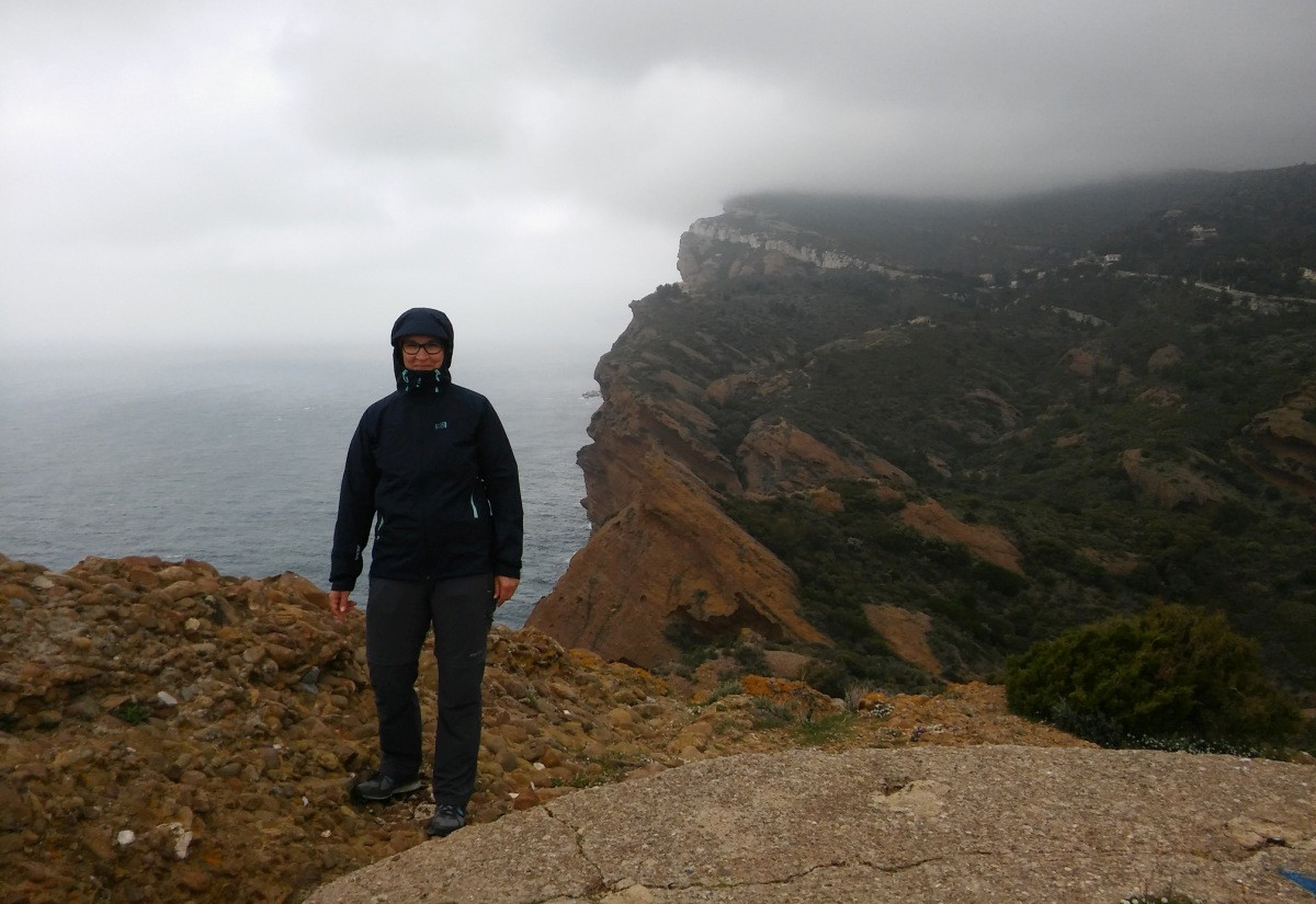 Alex cagoulée et la Grande Tête dans la brume. Photo © André M. Winter
