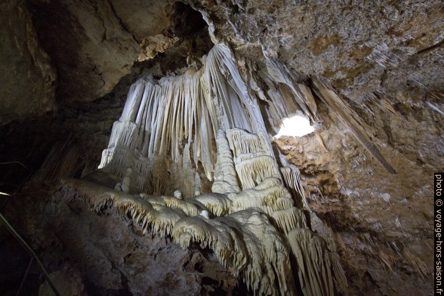 Paroi couverte de drapeaux dans la grande salle de la Grotte de Clamouse. Photo © André M. Winter