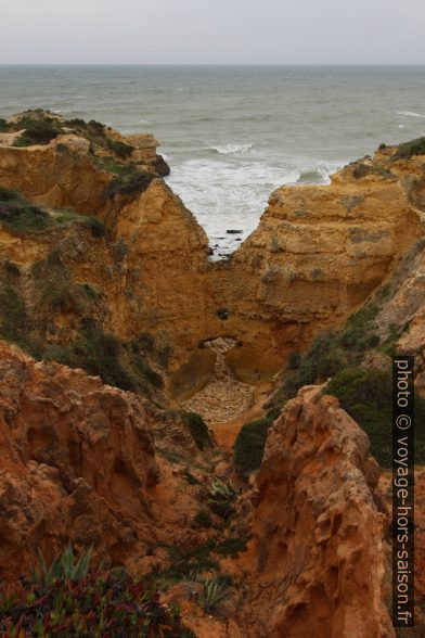 Mur de falaise percé à la base. Photo © André M. Winter