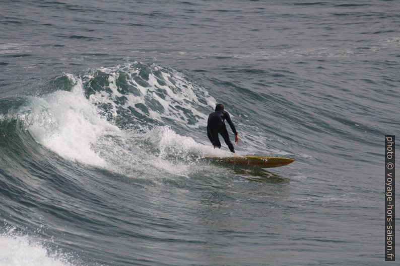 Un surfeur descend sur un court versant de vague. Photo © André M. Winter