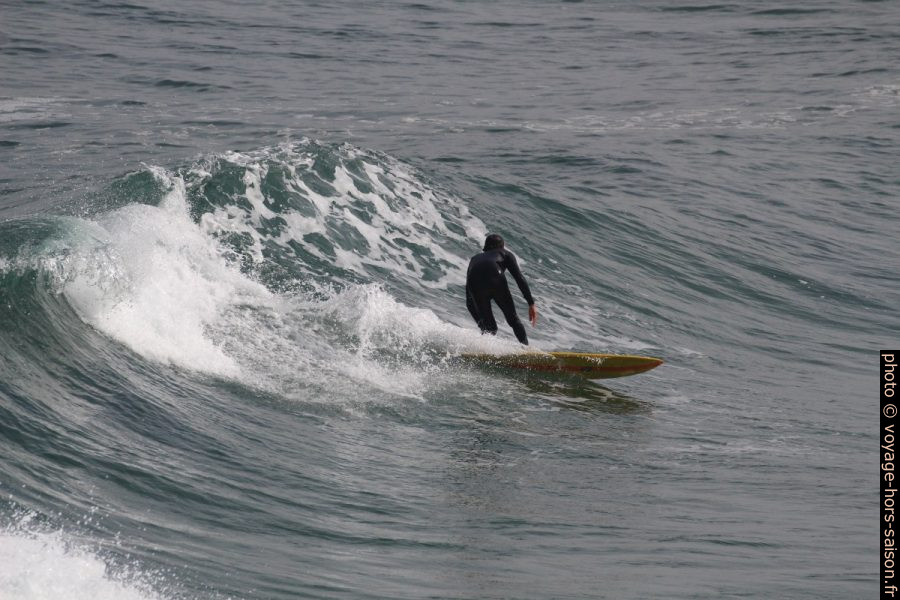 Un surfeur descend sur un court versant de vague. Photo © André M. Winter