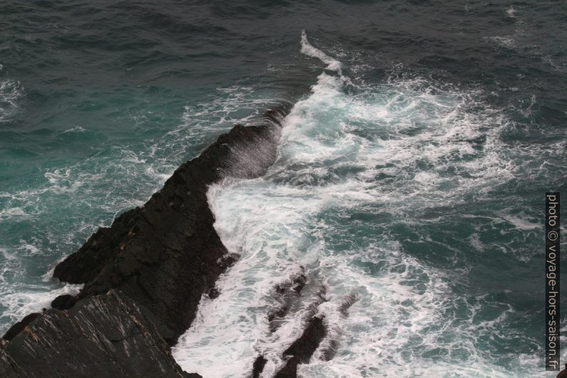 Remous des vagues sur un rocher s'avançant dans la mer. Photo © André M. Winter