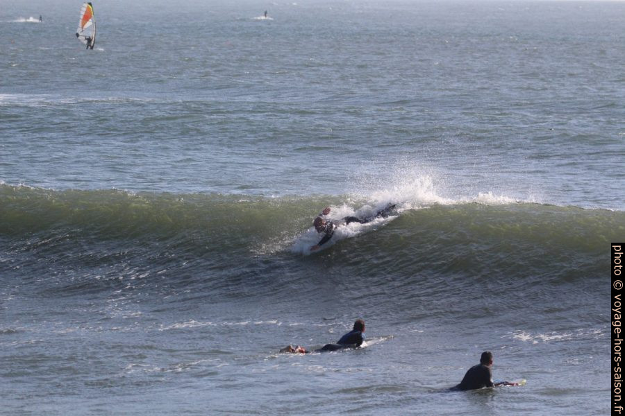 Des surfeurs sur une vague déferlante dans la lumière du soir. Photo © André M. Winter
