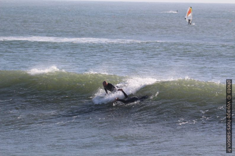 Un surfeur se lance pendant qu'un autre plonge. Photo © André M. Winter