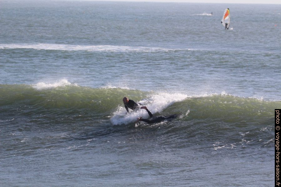 Un surfeur se lance pendant qu'un autre plonge. Photo © André M. Winter