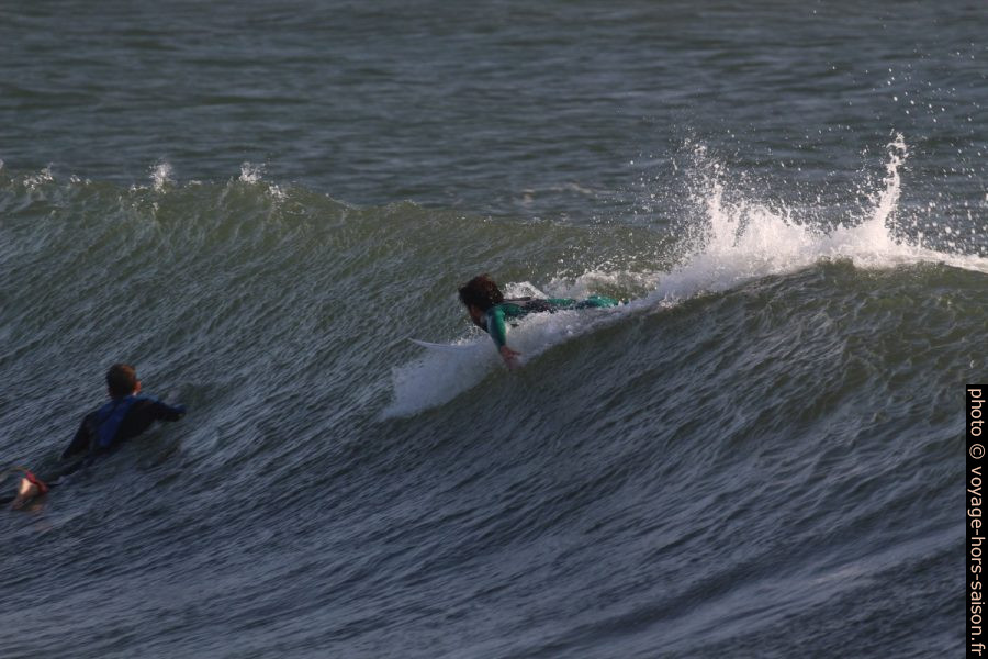 Un surfeur prend de l'élan sur une vague. Photo © André M. Winter