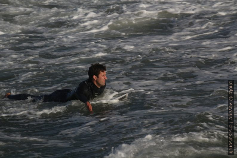 Surfeur ramant pour sortir vers les vagues. Photo © André M. Winter