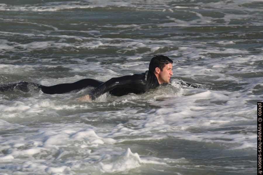 Surfeur ramant pour sortir vers les vagues. Photo © André M. Winter