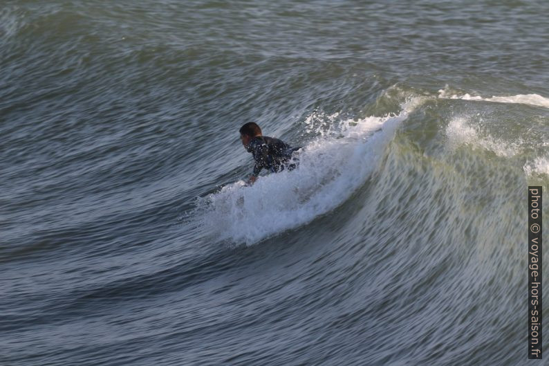 Un surfeur s'élance sur la vague. Photo © André M. Winter