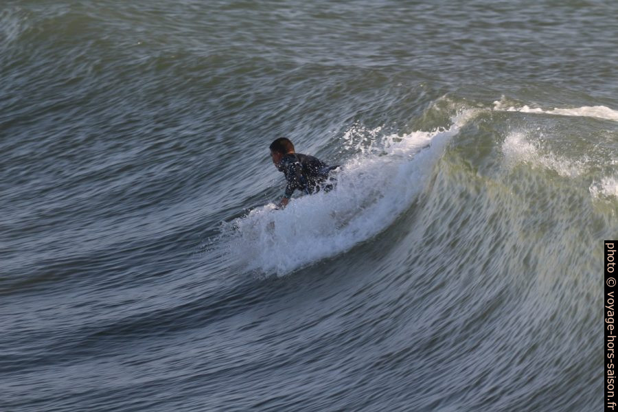 Un surfeur s'élance sur la vague. Photo © André M. Winter
