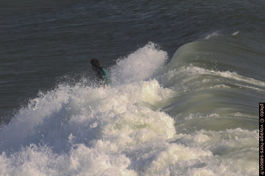 Un surfeur pris dans la mousse de la déferlante qui se brise. Photo © André M. Winter