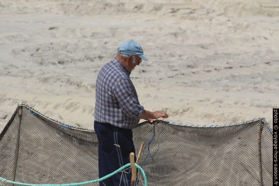 Un pêcheur coud une partie d'un filet de pêche. Photo © André M. Winter
