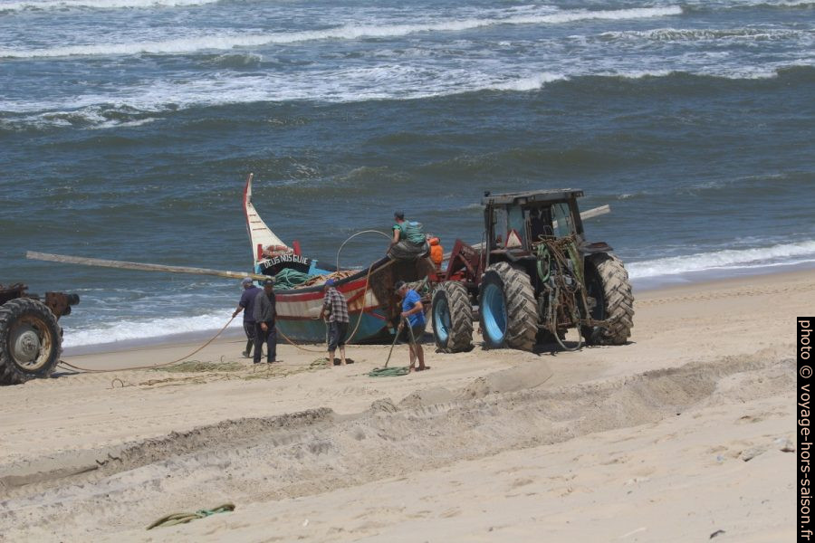 Un tracteur s'apprête à pousser la barque de pêcheurs Lago do Mar dans la mer. Photo © André M. Winter