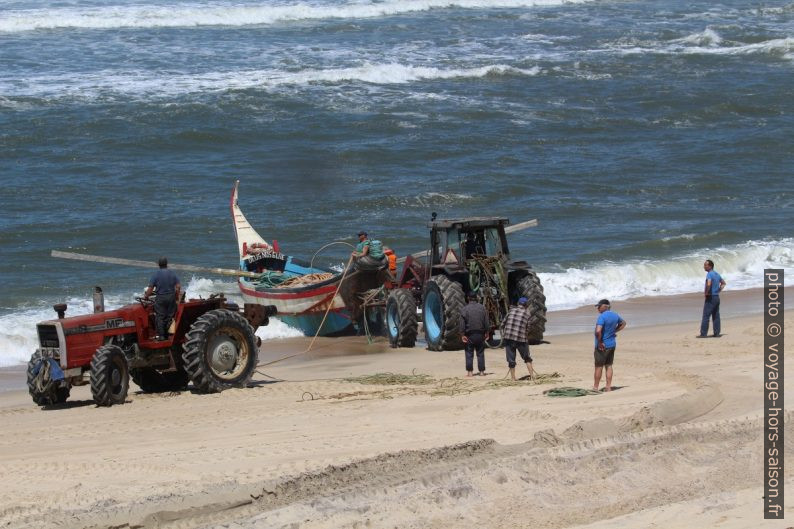 Un tracteur pousse la barque de pêcheurs Lago do Mar de la plage dans les vagues. Photo © André M. Winter