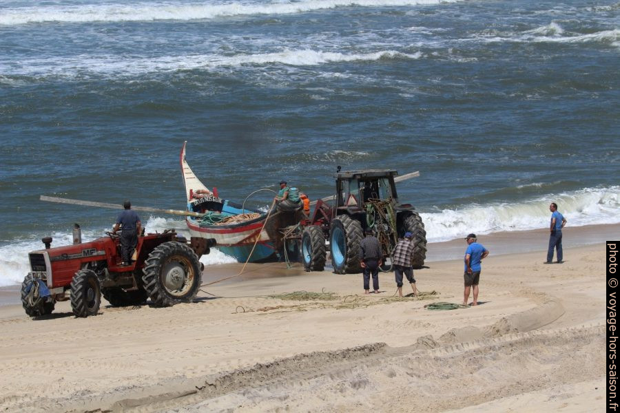 Un tracteur pousse la barque de pêcheurs Lago do Mar de la plage dans les vagues. Photo © André M. Winter