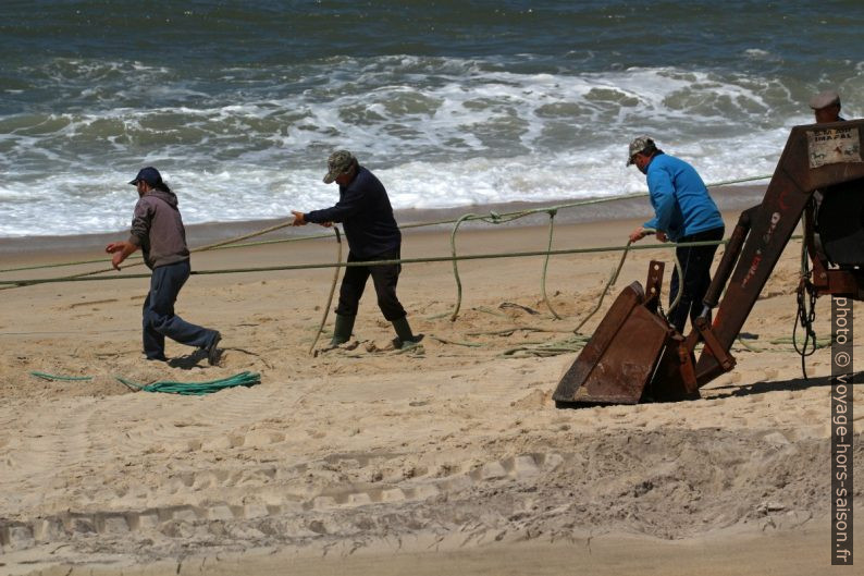 Des pécheur travaillent sur des cordages reliés au filet en mer. Photo © André M. Winter