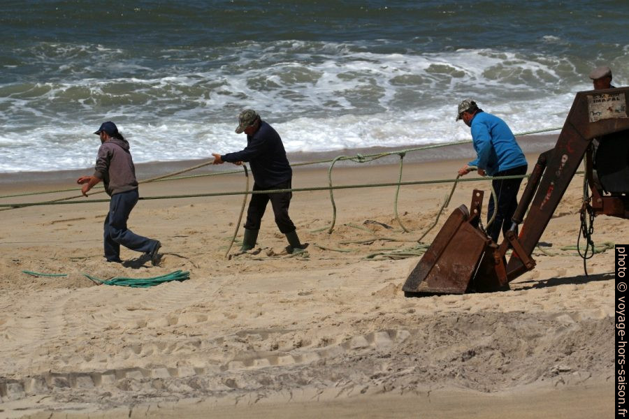 Des pécheur travaillent sur des cordages reliés au filet en mer. Photo © André M. Winter