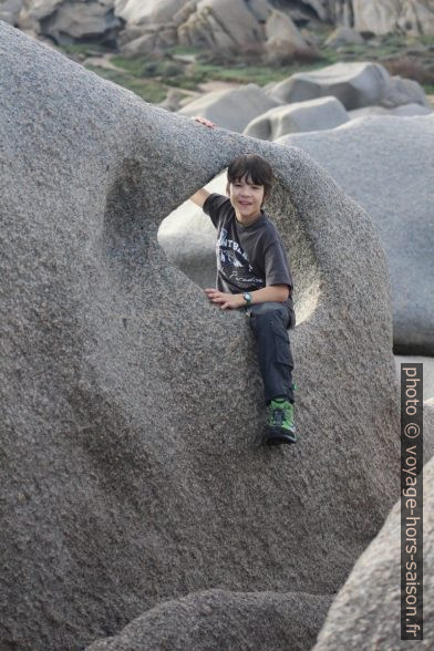 Nicolas assis dans un trou dans la roche. Photo © André M. Winter