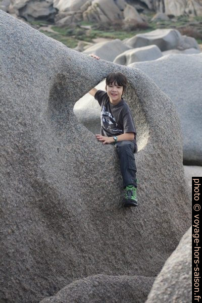 Nicolas assis dans un trou dans la roche. Photo © André M. Winter
