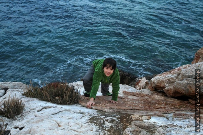 Nicolas grimpe sur les rochers au-dessus de la mer. Photo © Alex Medwedeff