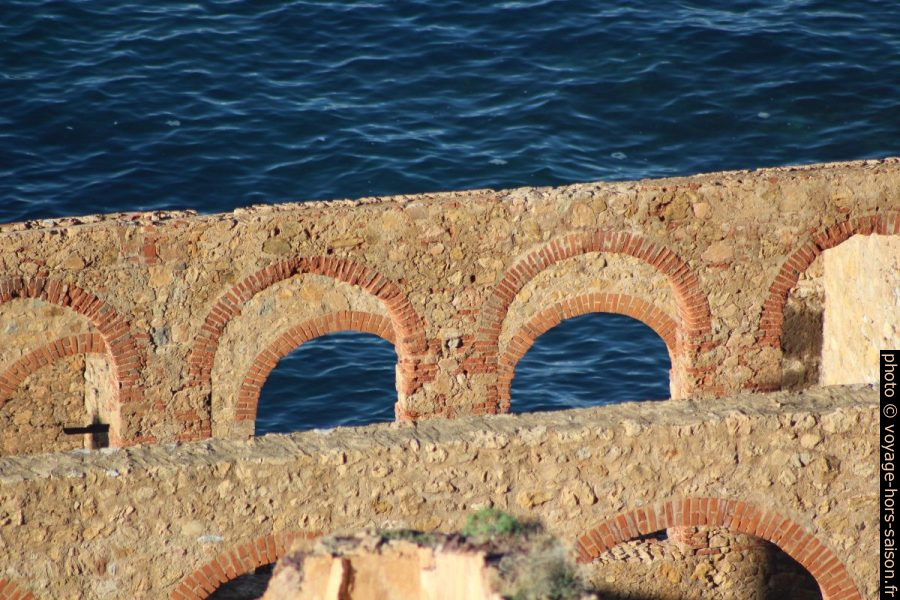 Murs et arcs de la Laverie Larmamora devant la mer bleue. Photo © André M. Winter
