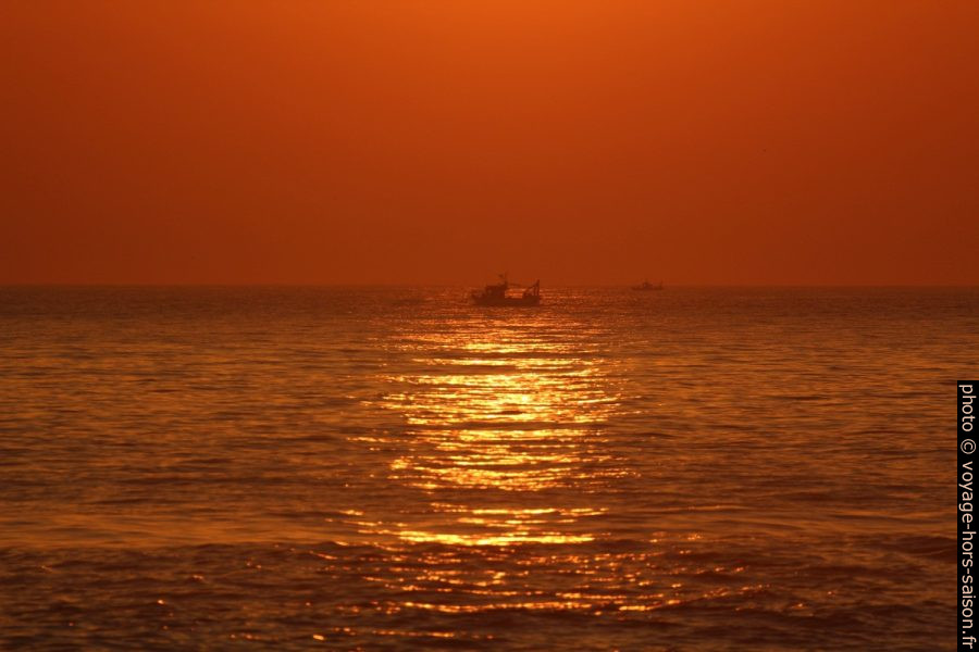 Des bateaux de pêche dans le coucher de soleil orange. Photo © André M. Winter