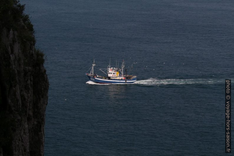 Un bateau de pêcheurs et la paroi près du Faro del Caballo. Photo © André M. Winter