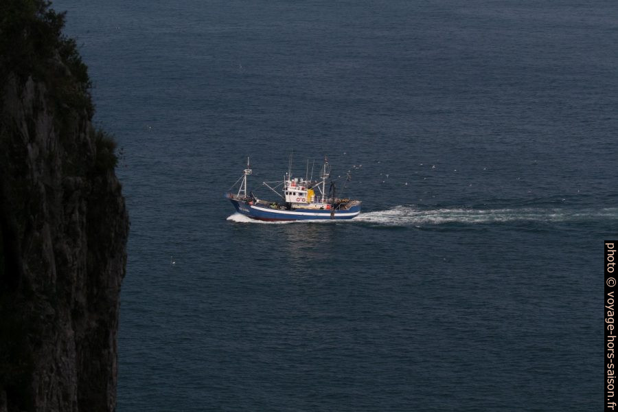 Un bateau de pêcheurs et la paroi près du Faro del Caballo. Photo © André M. Winter