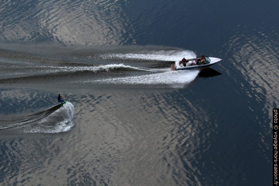 Vue plongeante sur un bateau tirant un homme en monoski nautique. Photo © André M. Winter