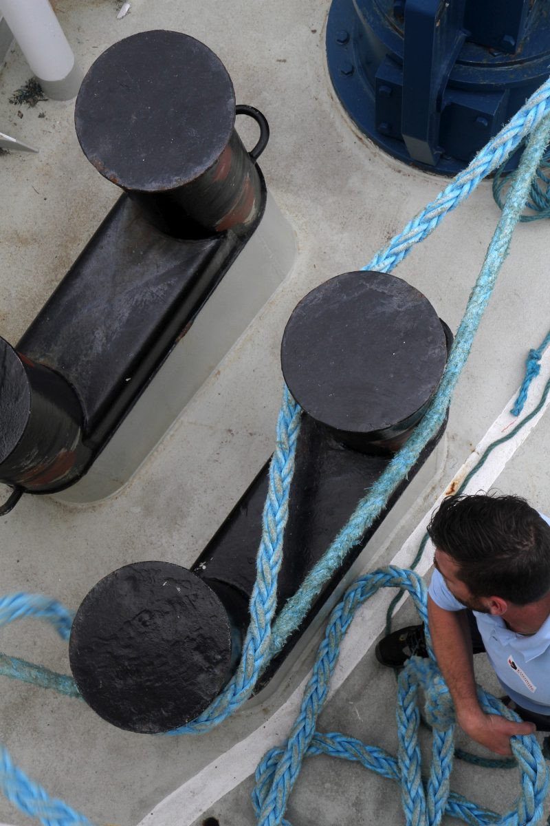 Un ouvrier passe les amarres sur des bollards. Photo © Alex Medwedeff