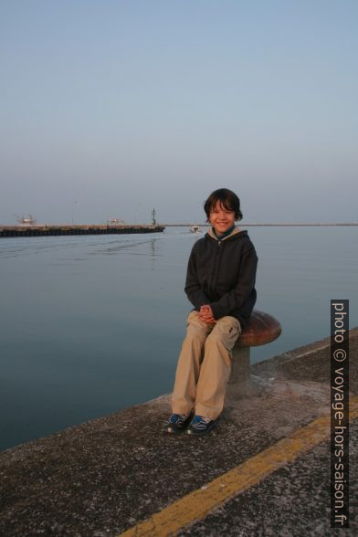 Nicolas assis sur une bitte d'amarrage du Molo Dalmazia de la Marina di Ravenna. Photo © André M. Winter