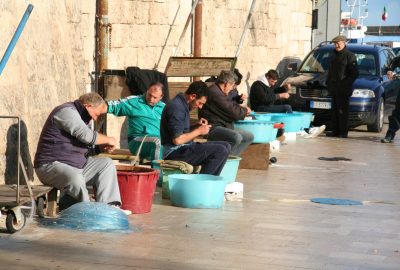 Pêcheurs travaillant à leurs lignes sur le port de Monopoli. Photo © Alex Medwedeff